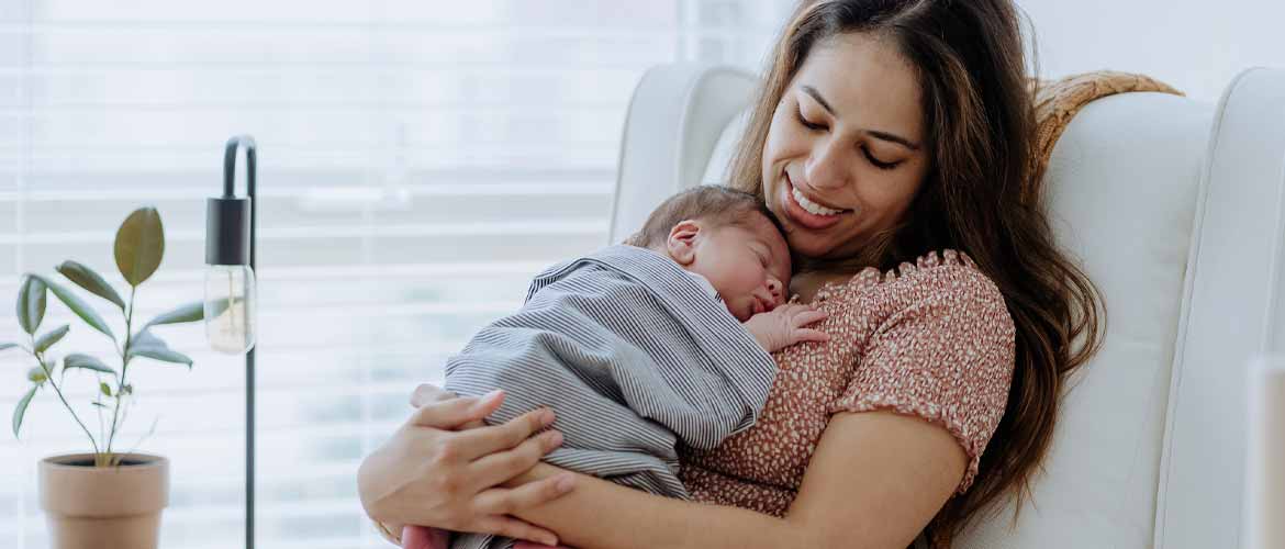 A mother holding her newborn after breastfeeding