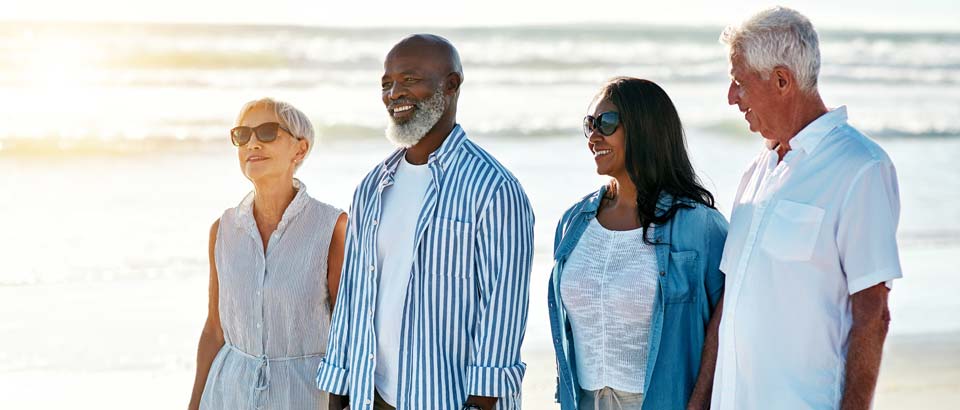 two couples walking on beach together