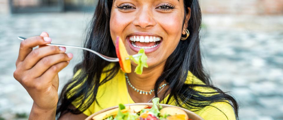 woman smiling eating salad