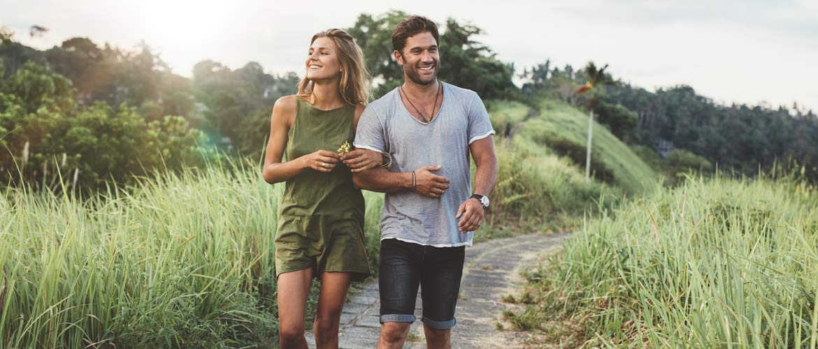 Couple joggin through a path in a field