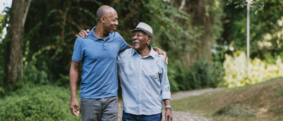 adult son and father walking with arms around shoulders