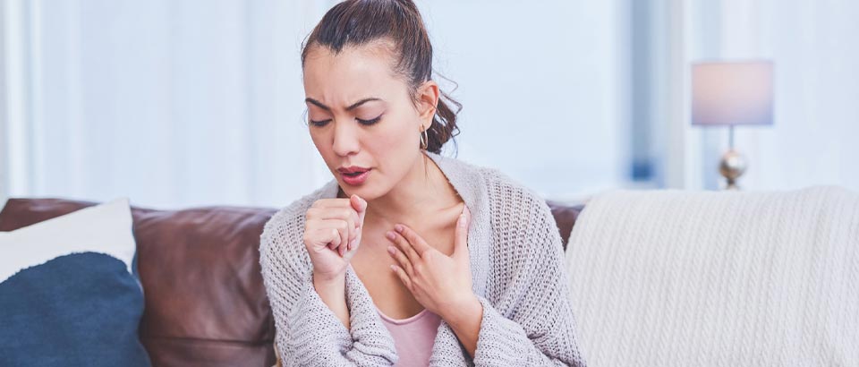 woman coughing into fist