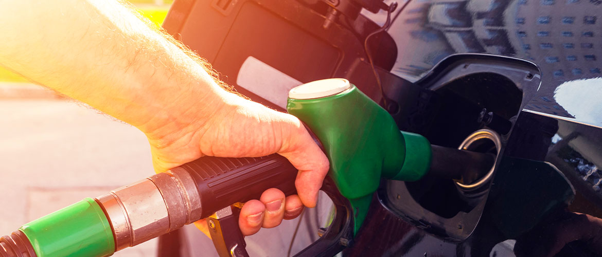 man pumping gas into black car