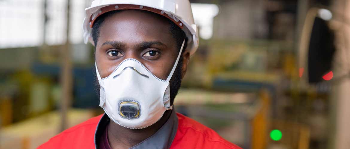 a warehouse employee wearing a face mask and hard hat