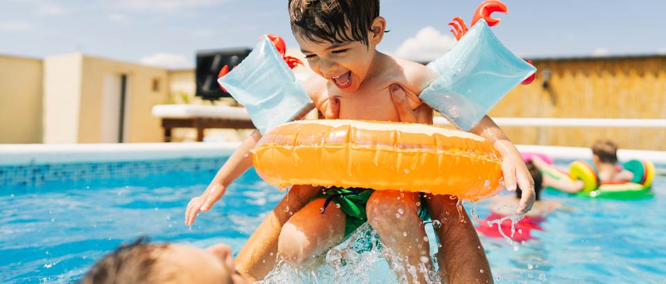 a parent with a child swimming in a pool having fun