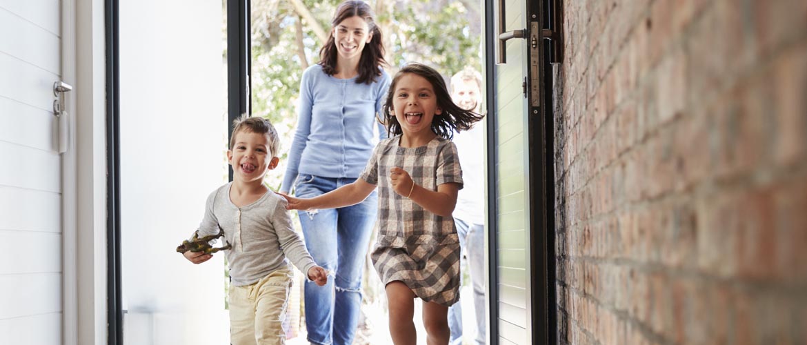 mother and two children entering their house