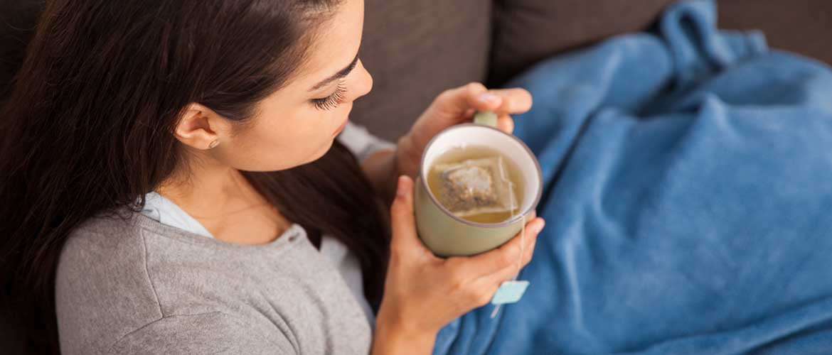 Woman looking down at her cup of tea.