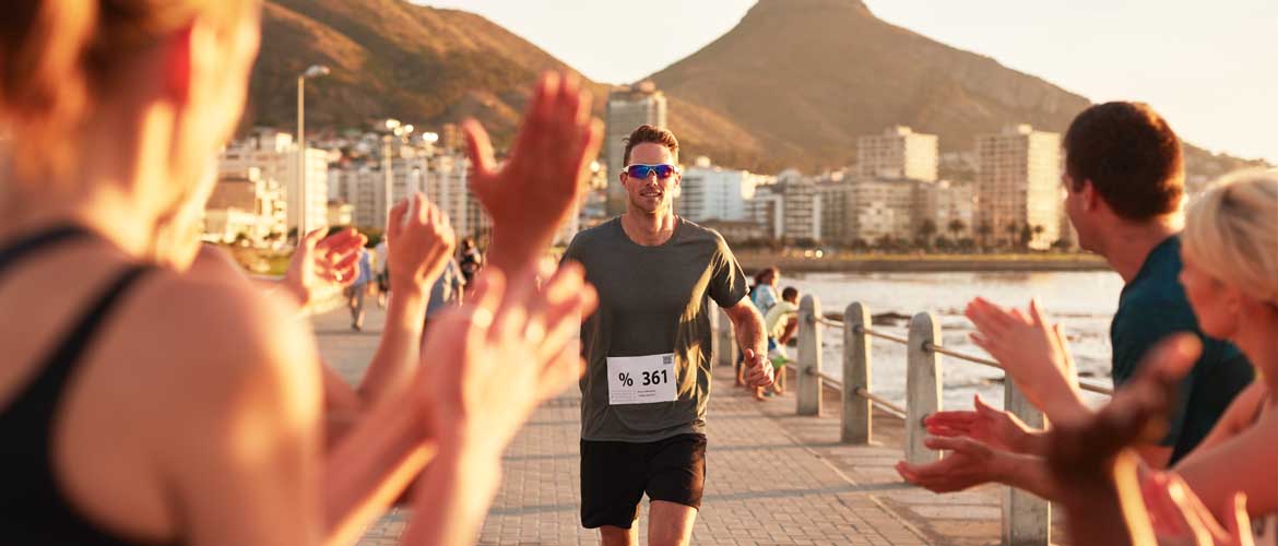 people cheering on man as he runs a marathon