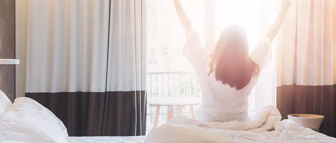 woman waking up from bed after sleeping