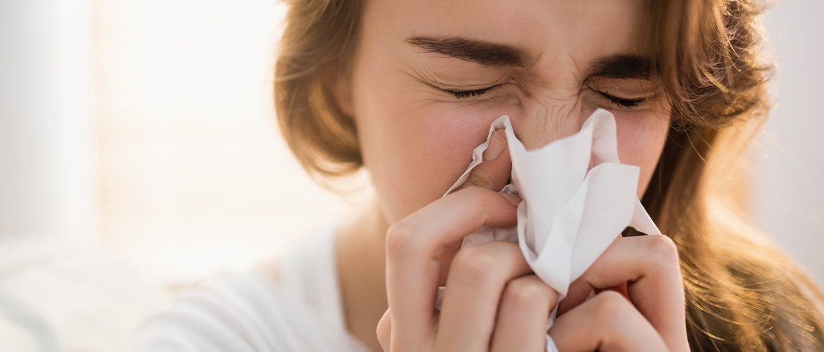 woman blowing her nose into a tissue