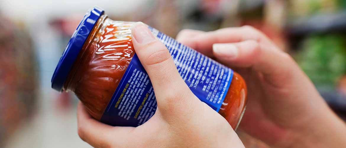 a person reading the nutrition label on a pasta jar