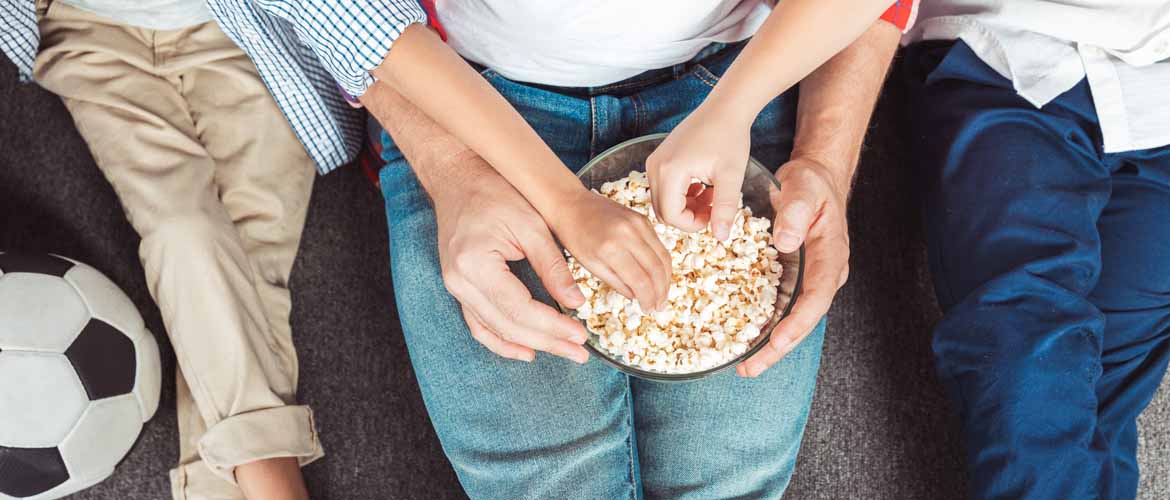 three people enjoying a bowl of popcorn together