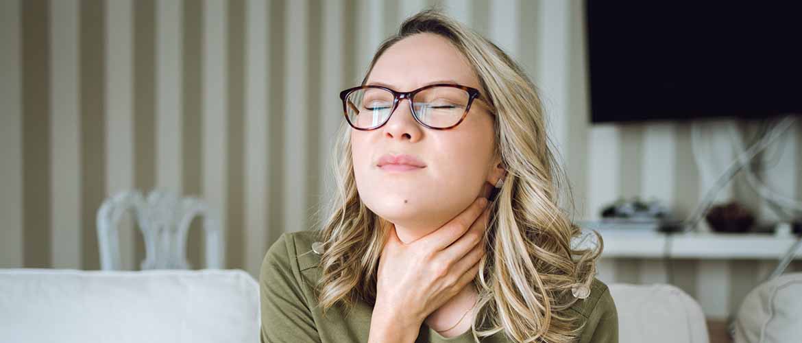 a young woman in pain grabbing her throat