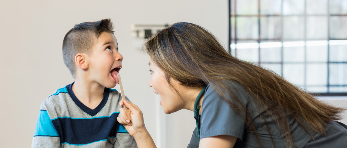 nurse looking at child's throat