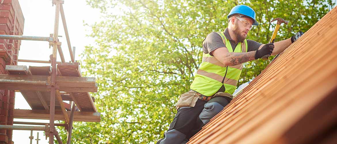 a construction worker hammering a roof