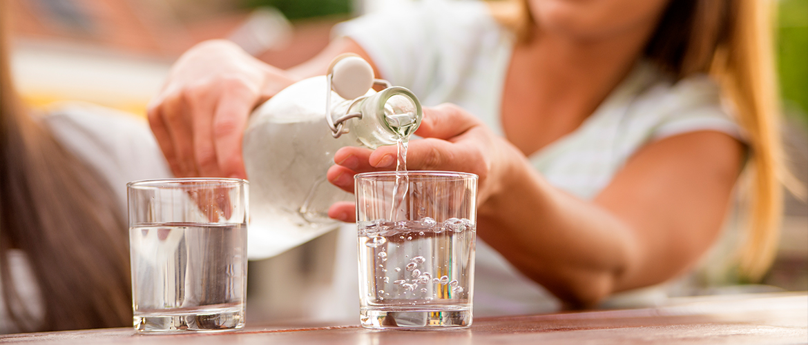 woman pouring water into glass