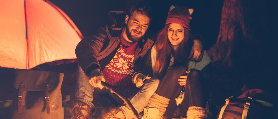 couple toasting marshmallows while camping