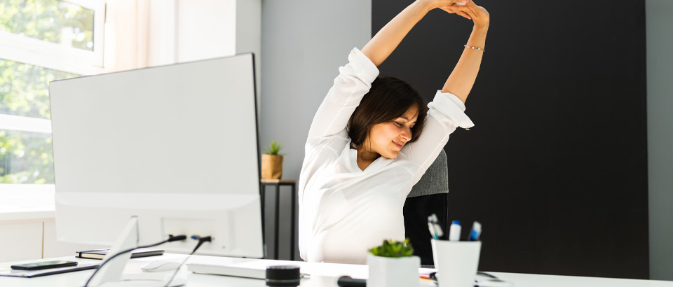 woman stretching at her desk