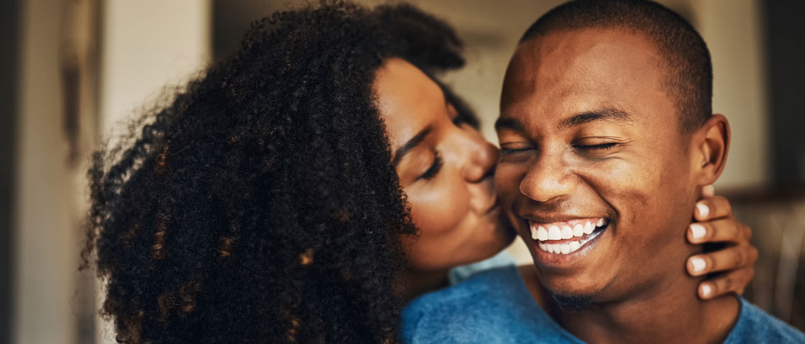 woman kissing male partner on cheek